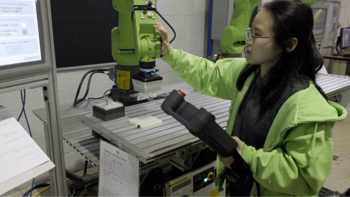 Student hand guiding a cobot at OCC